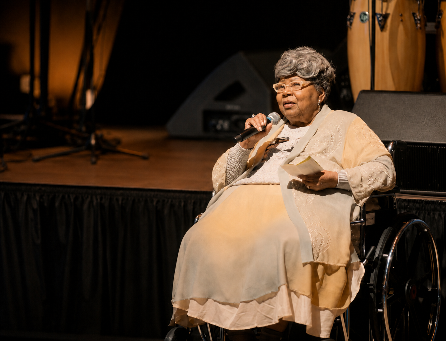 Princetta Rudd Newman speaking on stage with a microphone during a presentation